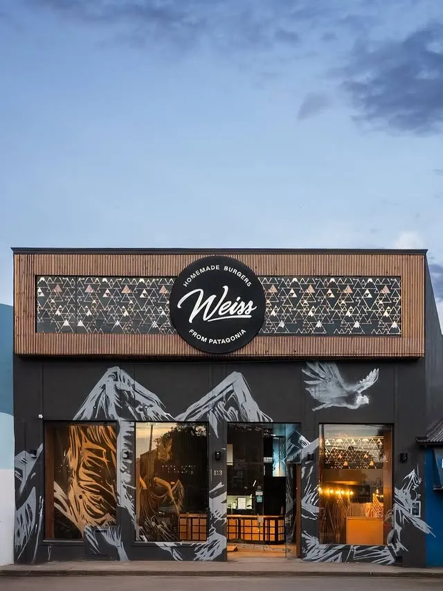 Fachada de un Weiss con mural de montañas y cóndor